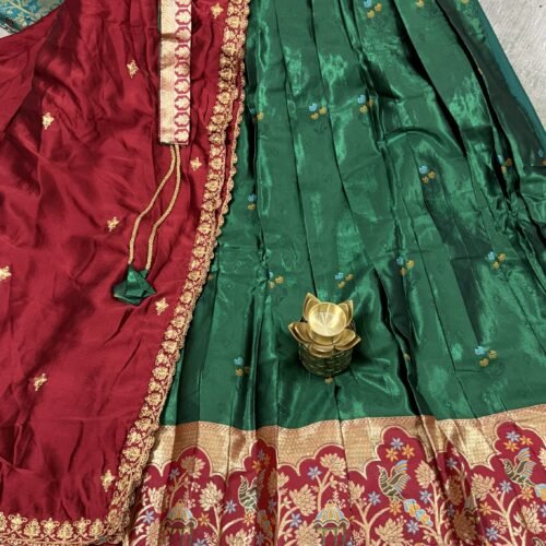 green and maroon half saree with kanchi tissue lehenga and elephant peacock border
